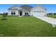 Two-story house with gray siding, white trim, and a three-car garage at 120 Lemon Drop Ln, Franklinton, NC 27525