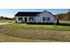 Newly built home with a white exterior, black roof, and grassy yard at 186 Pate Landing Dr, Selma, NC 27576