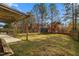 Large backyard with pergola, wooden bench, and tree line at 237 Sweet Violet Dr, Holly Springs, NC 27540