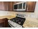 Stainless steel gas range and microwave in kitchen at 237 Sweet Violet Dr, Holly Springs, NC 27540