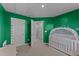 Green bedroom with crib and access to hallway at 268 Misty Pike Dr, Raleigh, NC 27603