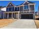 Two-story house with gray siding, stone accents, and a two-car garage at 347 N. Maple Walk Dr # 211, Garner, NC 27529