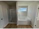 Bathroom with soaking tub, shower, and wood-look flooring at 36 Holly Grove Ln, Lillington, NC 27546