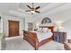 Main bedroom with tray ceiling, dark wood furniture, and neutral decor at 4105 Summer Brook Dr, Apex, NC 27539