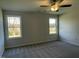 Spacious bedroom with neutral walls, plush carpeting, and two large windows at 50 Holly Grove Ln, Lillington, NC 27546