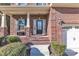 Brick home's front entrance with a black door and sidelights, a porch, and landscaping at 105 Valleycruise Cir, Garner, NC 27529