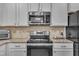 Modern kitchen with granite countertops, stainless steel appliances, and white cabinets at 105 Valleycruise Cir, Garner, NC 27529