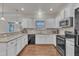 Modern kitchen with white cabinets, granite countertops, and stainless steel appliances at 105 Valleycruise Cir, Garner, NC 27529