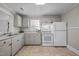 Galley kitchen with white appliances and light gray cabinets at 2220 May Dr, Burlington, NC 27215