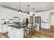 Modern kitchen with white cabinets, black countertops, and breakfast bar at 2330 Del Webb Gardens Dr, Fuquay Varina, NC 27526