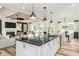 Open concept kitchen with island, white cabinets, and black countertops at 2330 Del Webb Gardens Dr, Fuquay Varina, NC 27526