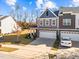 Two-story townhome, gray siding, white garage doors, and a side yard at 644 Barneswyck Dr, Fuquay Varina, NC 27526