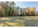 Large grassy backyard bordered by trees at 6506 Garrett Rd, Durham, NC 27707