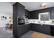 Modern kitchen with dark cabinetry, stainless steel appliances, and quartz countertops at 6506 Garrett Rd, Durham, NC 27707