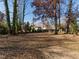 Large backyard with mature trees and patio at 808 Trail One, Burlington, NC 27215