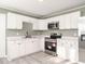 Modern kitchen featuring white cabinets, stainless steel appliances, and quartz countertops at 808 Trail One, Burlington, NC 27215