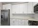 Kitchen with white cabinets, stainless steel appliances, and herringbone backsplash at 108 Pointe Crest Ct, Cary, NC 27513