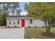 Newly renovated gray house with red door, gravel driveway, and landscaped yard at 1100 Pecan Pl, Durham, NC 27704