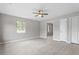 Bright living room with gray walls, light wood floors, and ceiling fan at 1100 Pecan Pl, Durham, NC 27704