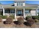 Inviting front porch with white railings and lush landscaping at 297 Denvale Dr, Selma, NC 27576