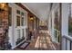 Spacious front porch with a wicker swing and brick flooring at 4027 Green Forest Ct, Rocky Mount, NC 27804