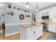 White kitchen features granite island, decorative shelving and stainless steel appliances at 4027 Green Forest Ct, Rocky Mount, NC 27804