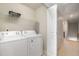 Well-lit laundry room with washer, dryer, and shelving at 4618 Merendino St, Raleigh, NC 27606