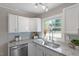 Modern kitchen with white cabinets, stainless steel appliances, and granite countertops at 609 E Cockrell St, Nashville, NC 27856