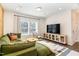 Living room featuring a green sectional sofa, TV, and neutral decor at 62 Tanglewood Pl, Angier, NC 27501