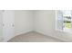 Empty bedroom with carpeted floor, door, and window with a yard view at 8656 Brixton Shay Dr, Raleigh, NC 27616