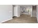 Living area with wood-look floors, showing kitchen and staircase at 8656 Brixton Shay Dr, Raleigh, NC 27616