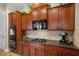 Well-equipped kitchen with dark wood cabinets and granite counters at 920 Chapanoke Rd, Raleigh, NC 27603