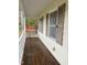 Covered front porch with wooden flooring and white railings at 6232 Dawn Dr, Hurdle Mills, NC 27541