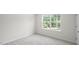 Bright bedroom with large window and neutral carpeting at 8658 Brixton Shay Dr, Raleigh, NC 27616