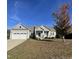 Ranch style home with gray siding, stone accents, and a two-car garage at 115 Hunterwood Pl, Benson, NC 27504