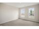 Bright bedroom with neutral walls and carpet, featuring two large windows at 516 Lemon Daisy Ln, Knightdale, NC 27545