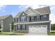 Two-story home with gray siding, white trim, and a two-car garage at 516 Lemon Daisy Ln, Knightdale, NC 27545