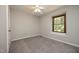 Spacious bedroom with carpet flooring, large window, white walls, and ceiling fan at 667 Bashford Rd, Raleigh, NC 27606
