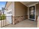 Side entry with a dark brown door, stone accents, and a view of the garage at 1211 Ballerina Ln, Durham, NC 27703