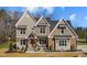 Two-story house with stone and wood accents, a covered porch, and a landscaped yard at 145 Wiggins Rd, Louisburg, NC 27549