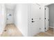 White hallway with light wood floors and doors to rooms at 408 Cherry St, Fuquay Varina, NC 27526