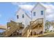 Two-story white houses with wooden decks and stairs, offering curb appeal at 408 Cherry St, Fuquay Varina, NC 27526