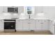 Modern kitchen with white cabinets, quartz countertops, and stainless steel appliances at 408 Cherry St, Fuquay Varina, NC 27526
