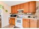 Kitchen features wood cabinets, white appliances, and tiled backsplash at 7217 Blannie Farms Ln, Willow Springs, NC 27592