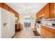 Galley kitchen with wood cabinets, white appliances, and tiled floor at 7217 Blannie Farms Ln, Willow Springs, NC 27592