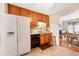 Kitchen with wood cabinets, white appliances, and tiled floor at 7217 Blannie Farms Ln, Willow Springs, NC 27592