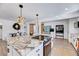 Modern kitchen with granite island, white cabinets, and stylish light fixtures at 211 E Lizzie St, Selma, NC 27576