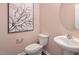 Small bathroom with toilet, sink, and framed wall art at 2243 Horton Park Drive, Apex, NC 27539