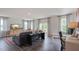 Spacious living room with hardwood floors, large windows, and a sectional sofa at 2243 Horton Park Drive, Apex, NC 27539