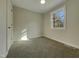 Well-lit bedroom featuring a window and carpet flooring at 302 N Montreal Ct, Cary, NC 27511